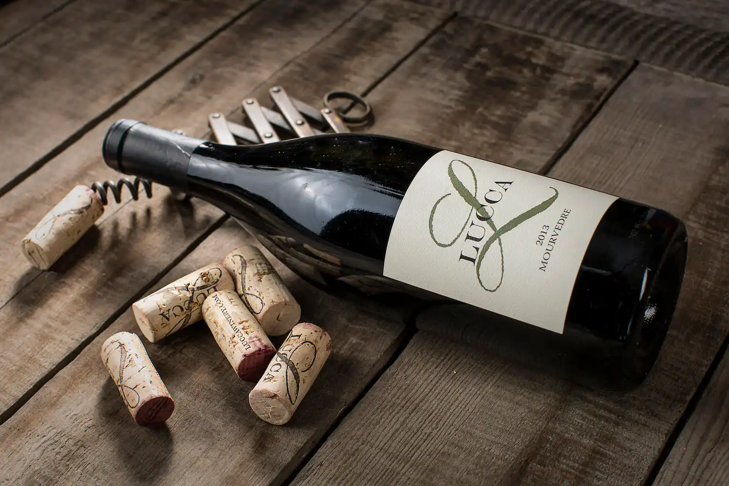A Lucca Winery bottle and corks on old wood
