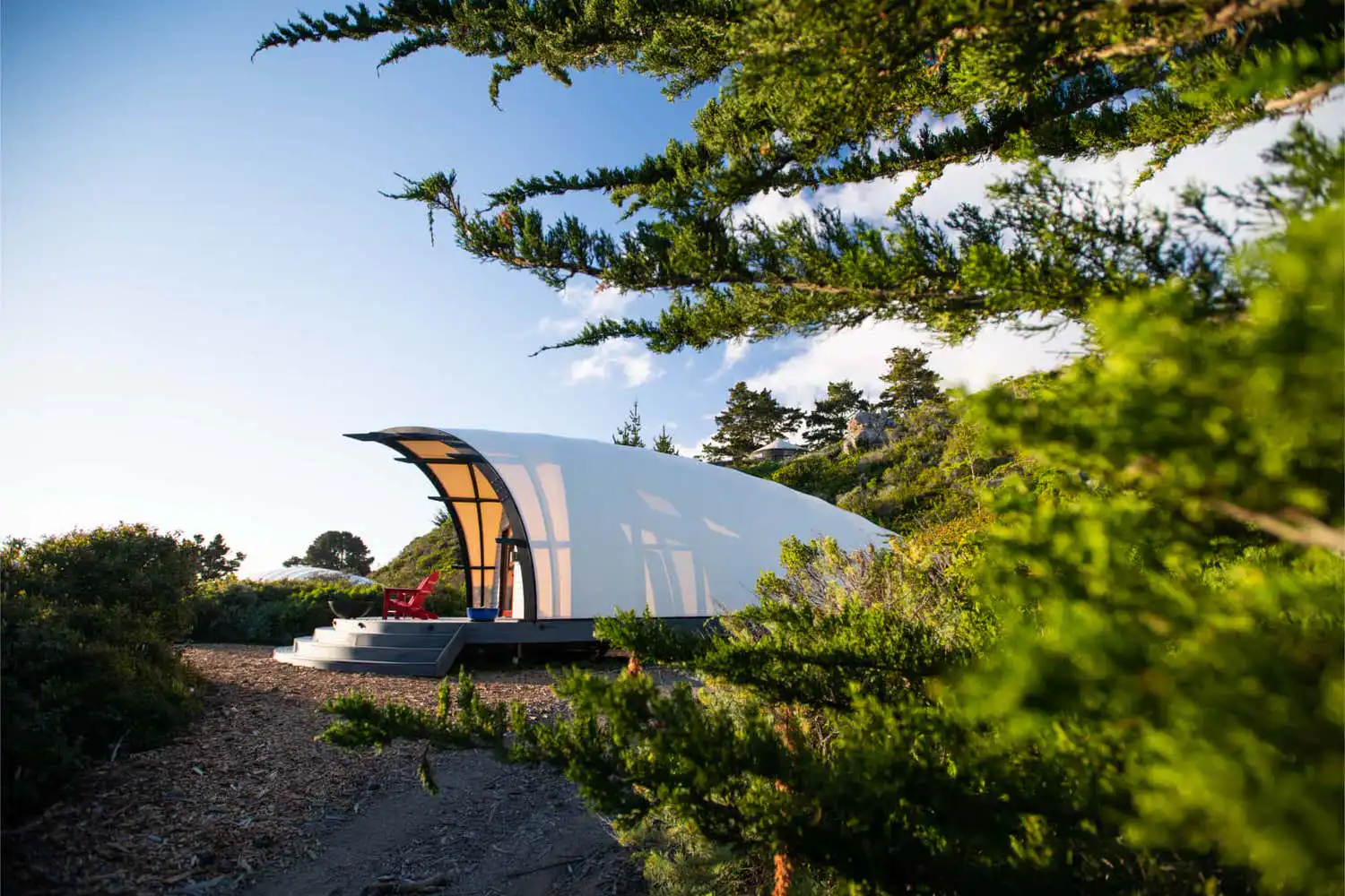 A canvas-roofed cabin among cypress trees at Treebones Resort